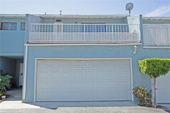 Front view of a two-story building with an attached garage and a balcony.