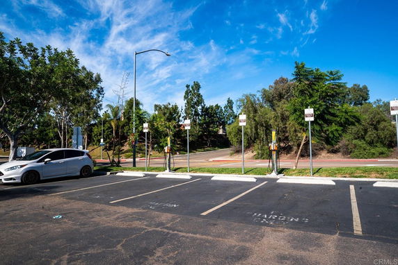 Outdoor parking area with electric vehicle charging stations and a parked car.
