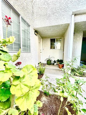 Front view of a house entrance with a small porch and plants around.