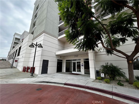 Front view of a multi-story building entrance with nearby trees.