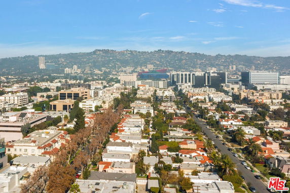 Panoramic view of a cityscape with buildings and hills in the background.