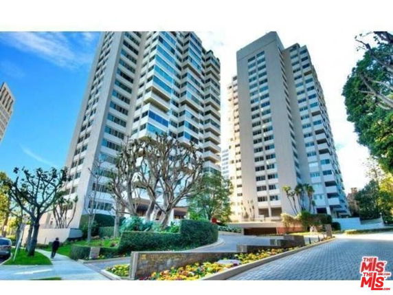 Front view of a high-rise residential building with multiple balconies.