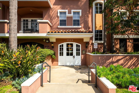Front view of a multi-story building with balconies and a central entrance.