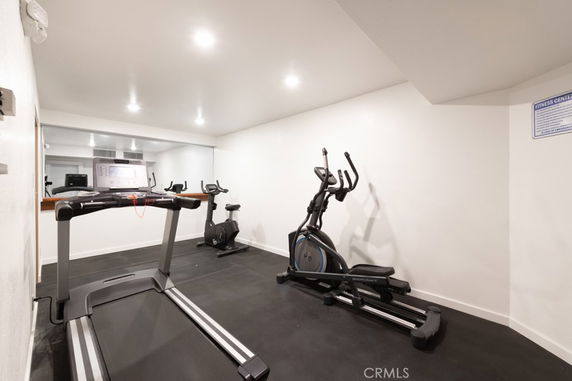 Indoor gym area with exercise equipment, including a treadmill and an elliptical machine.