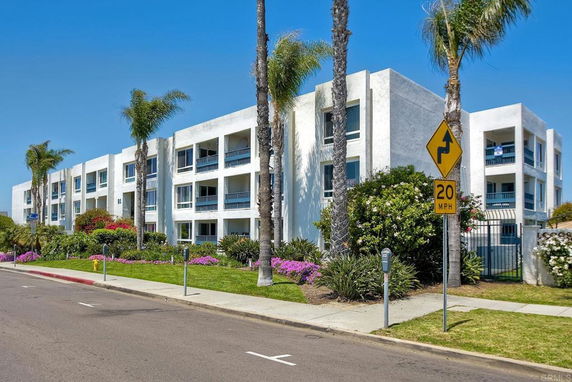 Front view of a three-story apartment building with balconies.