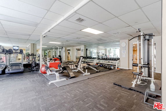 Indoor area with gym equipment and mirrored walls.