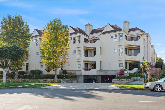 Front view of a multi-story residential building with a parking entrance.