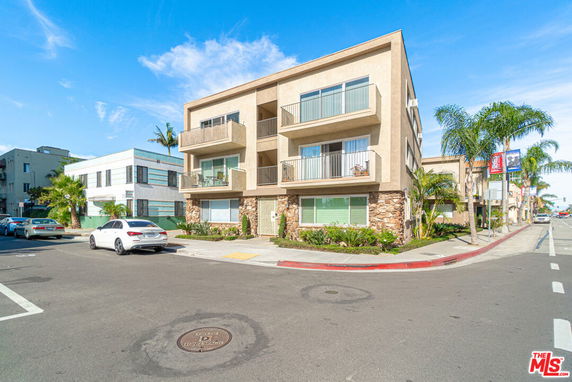 Front view of a three-story apartment building with balconies.