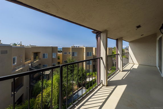 Balcony view of apartment buildings and surrounding greenery.