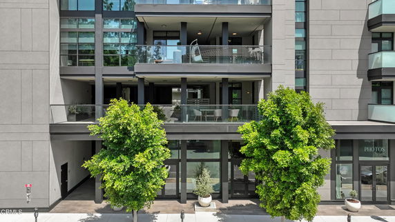 Front view of a multi-story building with balconies and large glass windows.