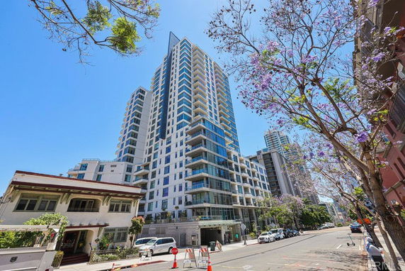 Front view of a high-rise residential building with multiple balconies and glass windows.