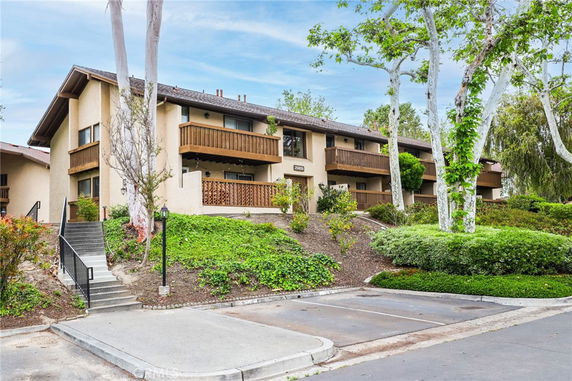 Front view of a two-story building with balconies and sloped roof.