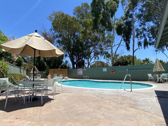 Outdoor swimming pool area with lounge chairs and umbrellas.
