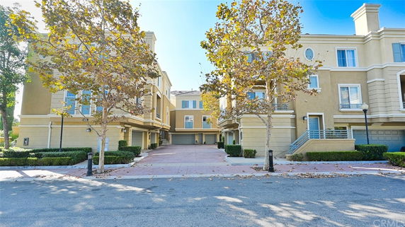 Front view of a multi-story apartment complex with garages.