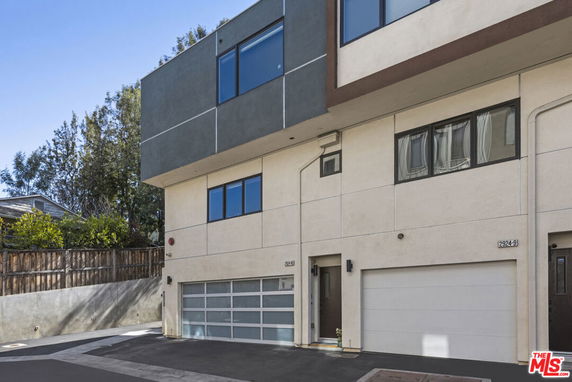 Front view of a modern multi-story building with a garage.