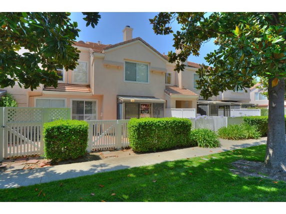 Front view of a two-story townhouse with a fenced front yard.