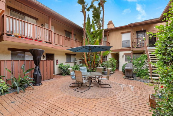 Courtyard view of a two-story building with outdoor seating and plants.