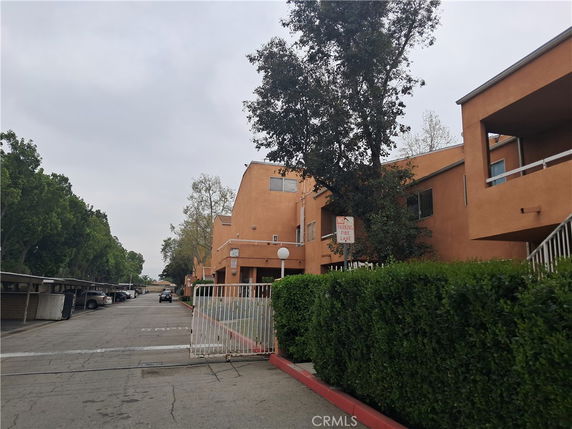 Front view of a multi-story building with a gated entrance.