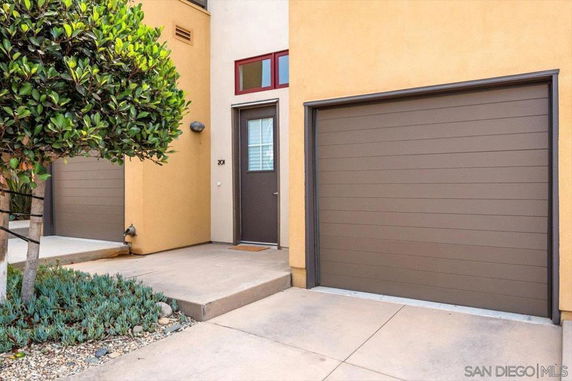 Front view of a house with a garage door and an entry door.