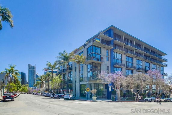 Front view of a multi-story modern apartment building with balconies and large windows.