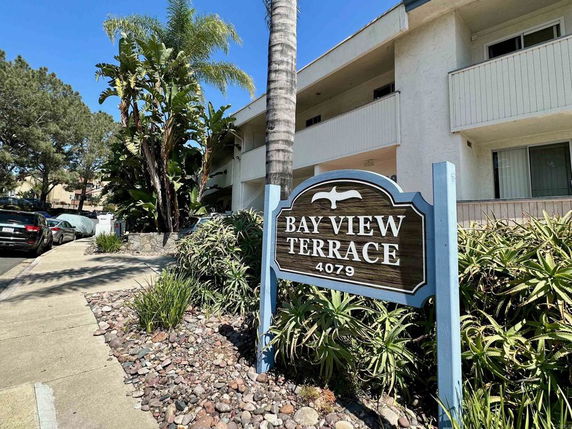 Front view of an apartment building with balconies and a sign that reads 'Bay View Terrace 4079'.