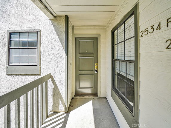 Front view of an entryway with a door and two windows.
