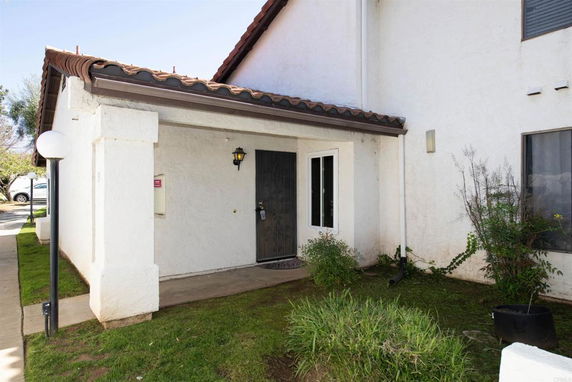Front view of a house with a covered porch and tile roof.