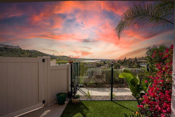Panoramic view of a scenic landscape with vibrant skies seen from inside a fenced area.