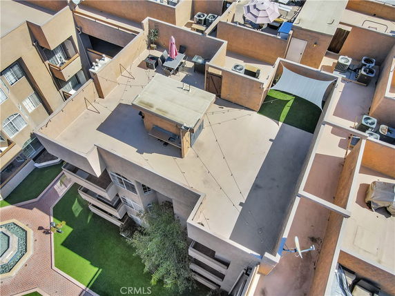 Rooftop view of a building with seating area and greenery.