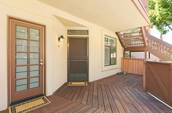 Front view of a house entrance with wooden steps and door.