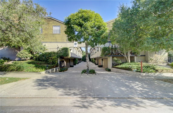 Front view of a multi-level residential building with a central access driveway.
