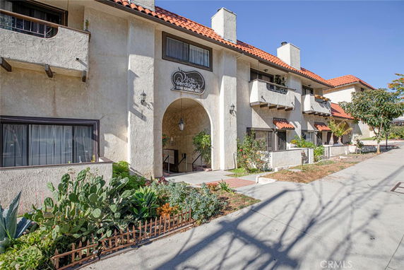 Front view of a two-story building with balconies and decorative arches.
