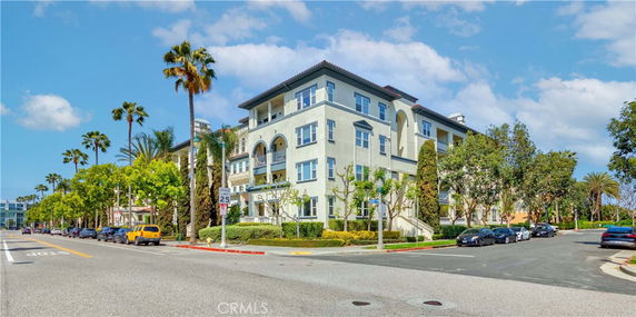 Front view of a multi-story residential building with an arched entrance.