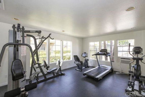 Indoor gym area with exercise machines and large windows.