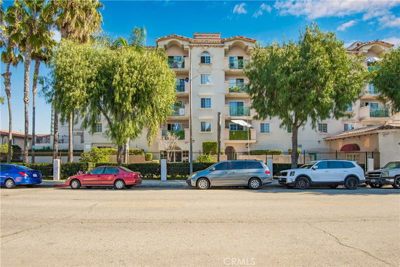 Front view of a multi-story apartment building with balconies.