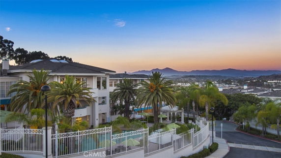 Panoramic view of surrounding areas with a large building and palm trees in the foreground.