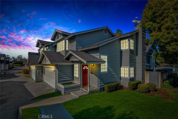 Front view of a two-story house with a garage and red front door.