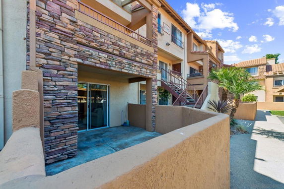 Front view of a multi-story residential building with stone and stucco exterior.