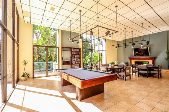 Indoor recreation area with a pool table, chairs, and tables.