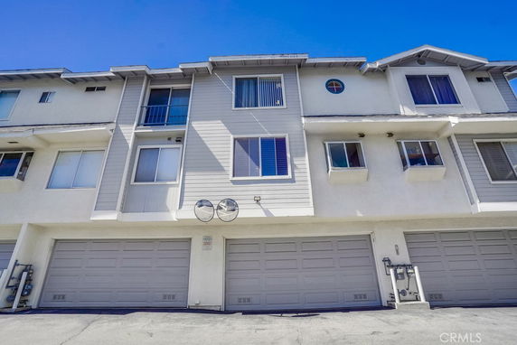Front view of a multi-story residential building with garages.