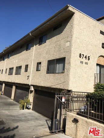Front view of a multi-story building with garage doors.