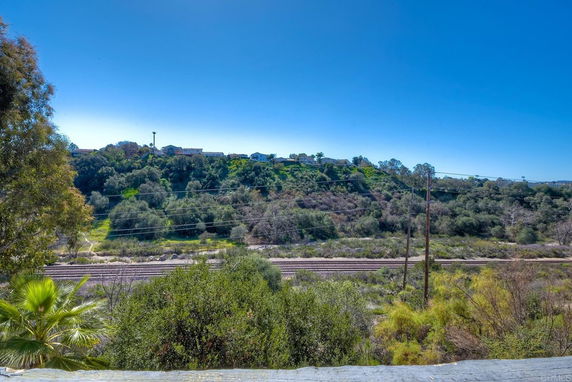 Wide view of greenery and distant hills under a clear blue sky.