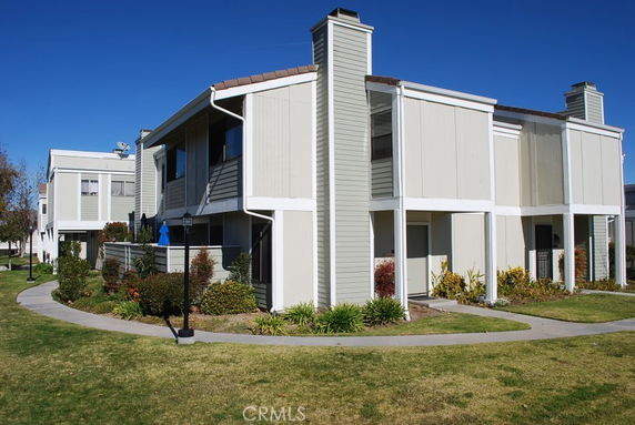 Front view of a multi-story residential building with chimneys.
