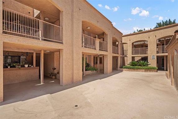 Front view of a two-story building with balconies and arched openings.