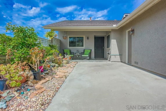 Front view of a house with a patio and garden area.