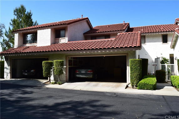 Front view of a two-story house with a tile roof and attached double garage.