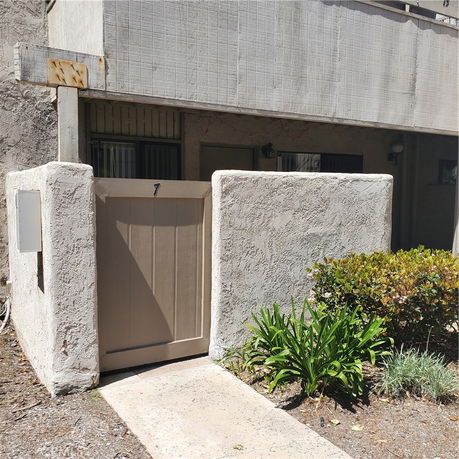 Front view of a structure with a wooden gate and concrete walls.