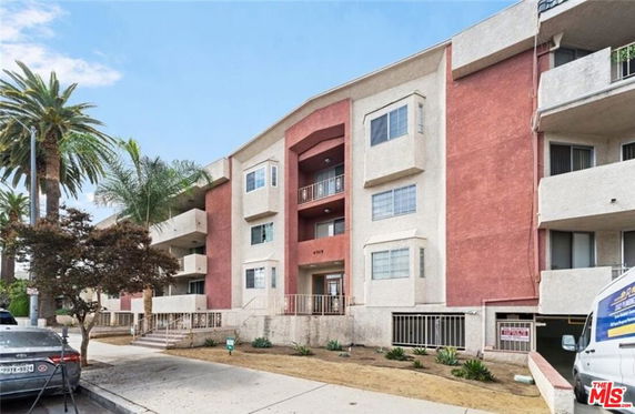 Front view of a multi-story apartment building with balconies.
