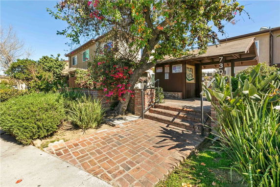 Front view of a house with brick pathway and covered entrance.