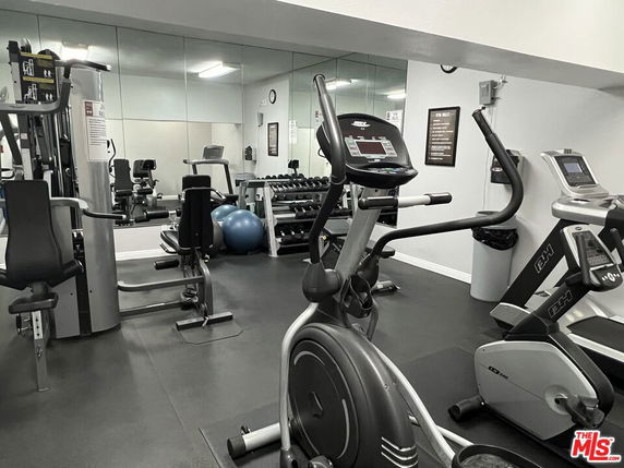 Interior view of a gym with exercise equipment and mirrors.